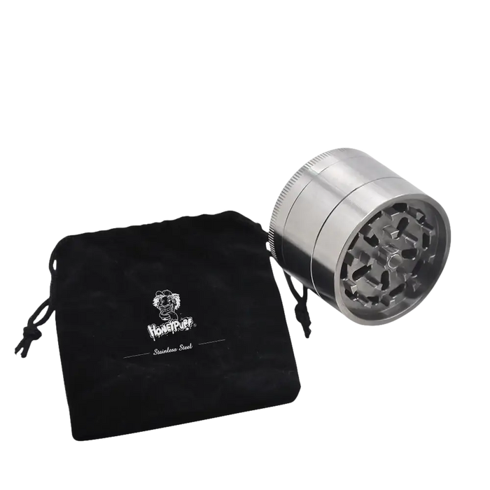 Silberner Metallkräutergrinder mit schwarzem Kordelzugbeutel.